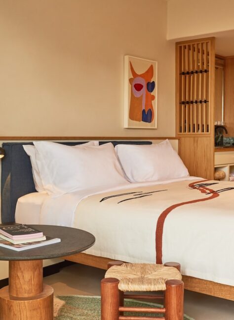 A hotel room featuring a neatly made bed, a comfortable chair, and a small table.