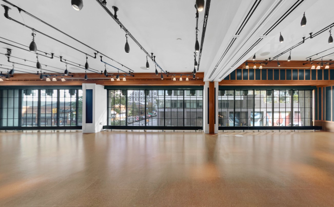 A low ceiling venue with studio style lights and floor to ceiling windows provides a place for gathering