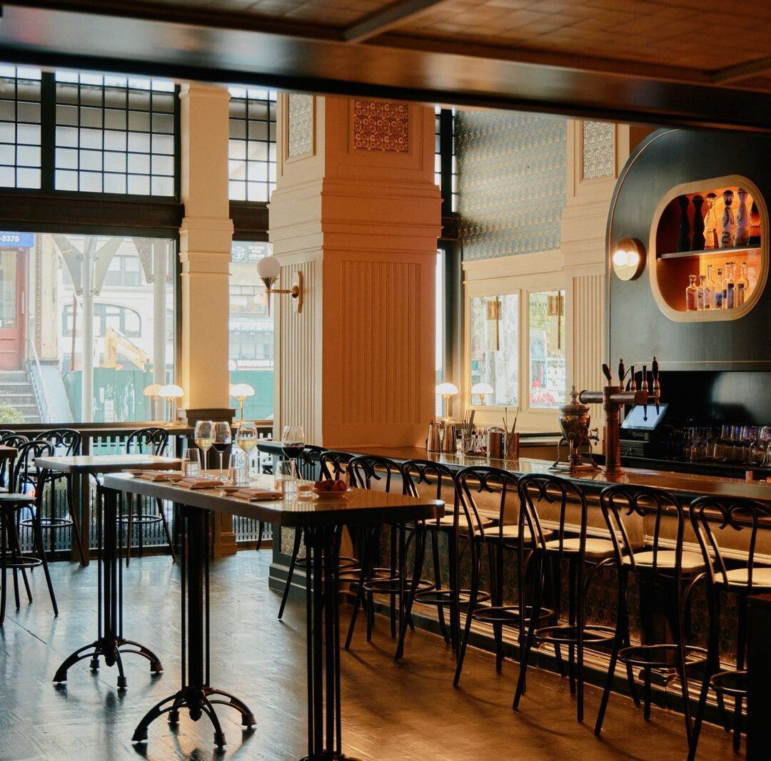 Bistro 29 lobby view image of high top tables, large open windows and bar seating area.