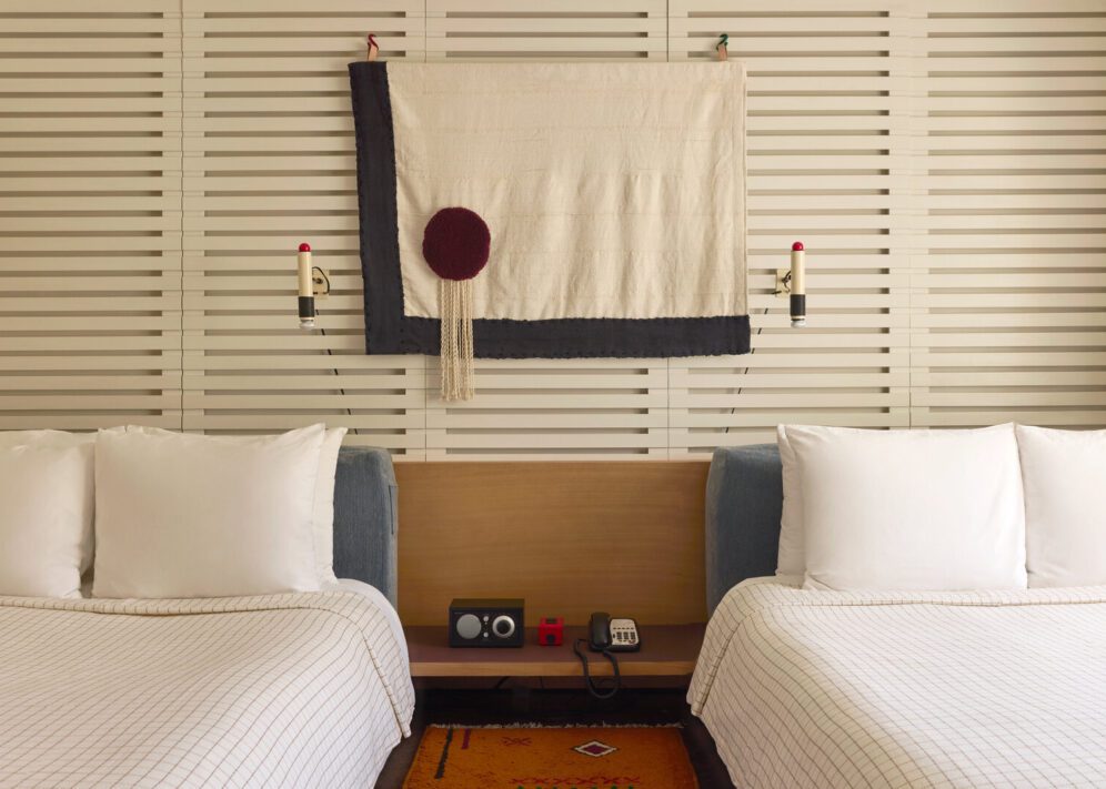A bluetooth radio and phone sit between two beds