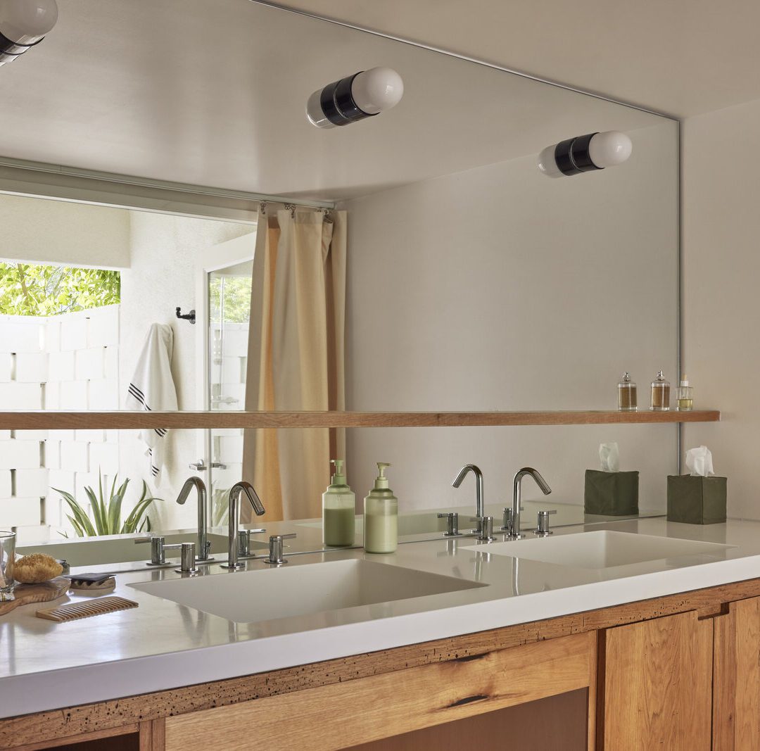 A modern bathroom featuring two sinks and a large mirror above them, reflecting the stylish decor