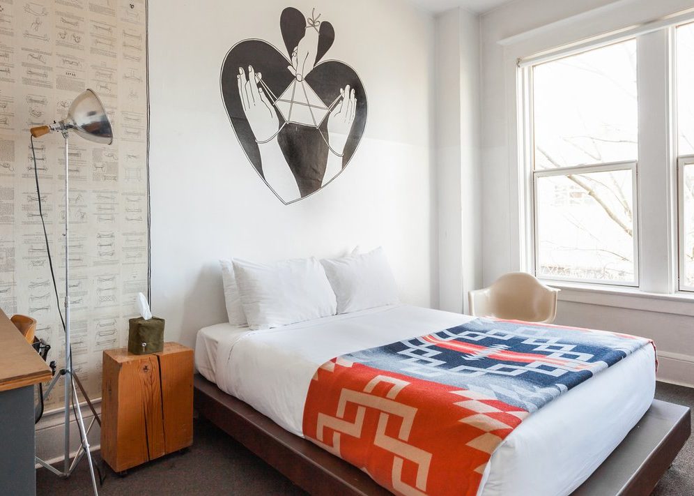 a bed with bright, ornate bedding is drenched in natural sunlight