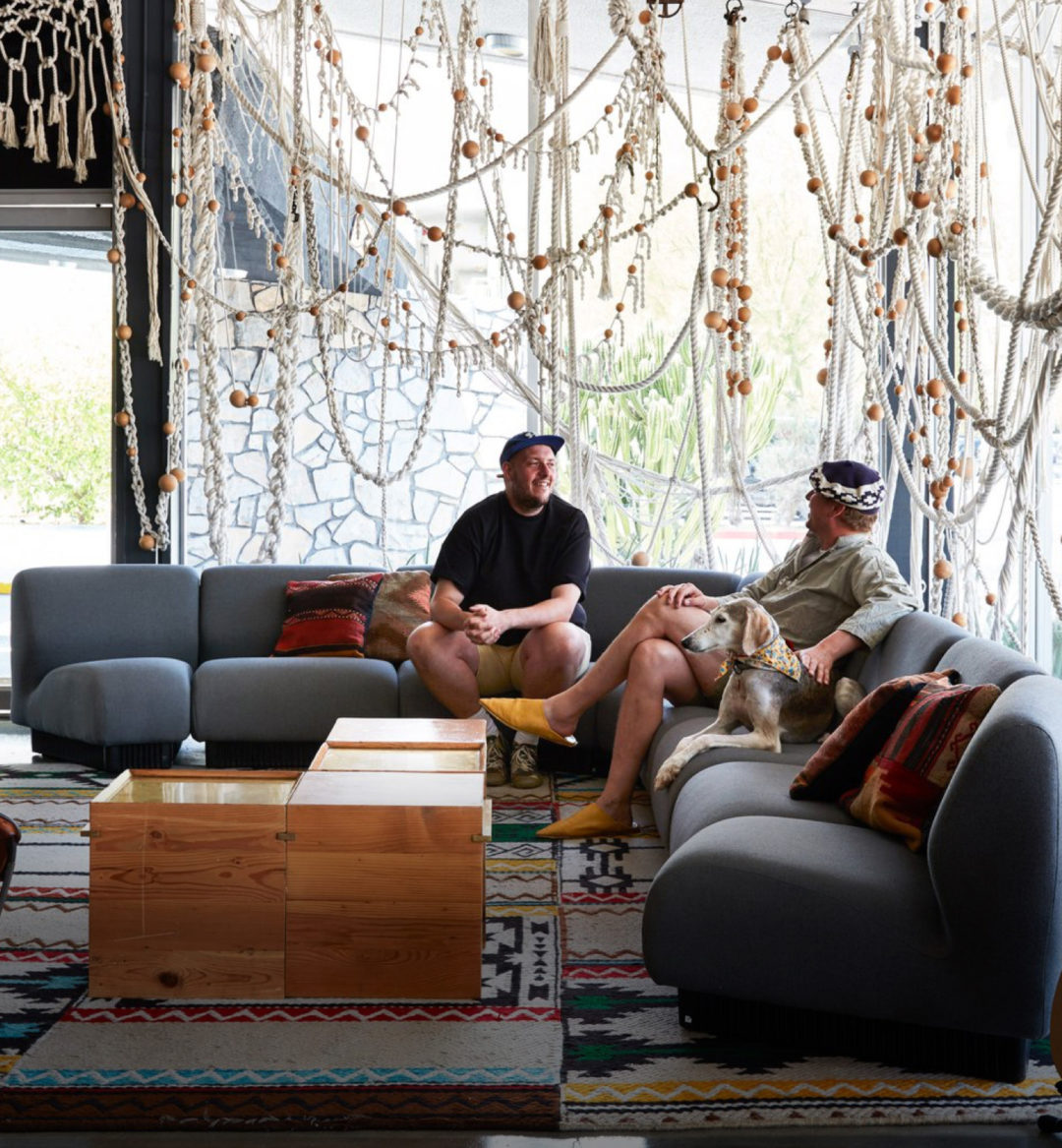 Two people and a dog sitting on couches