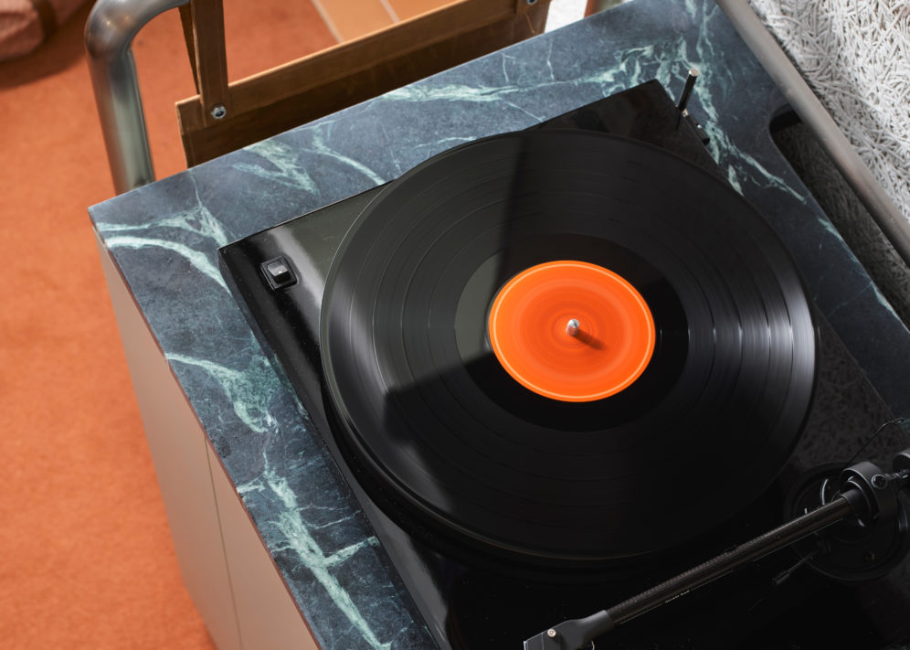 An active record player sits on top of black granite, spinning sounds for the room