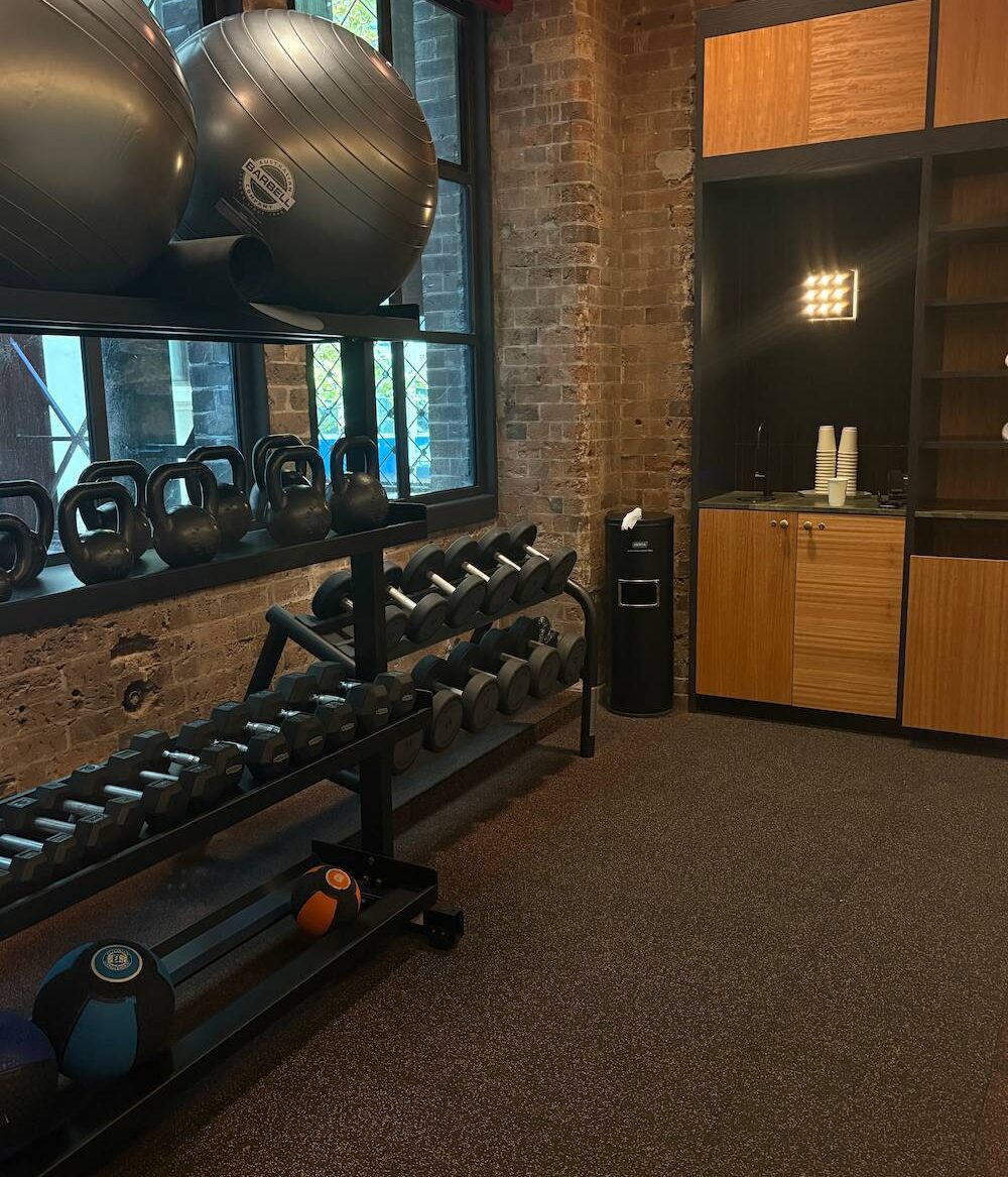 a photo of a gym with equipment that includes kettlebells, free weights, medicine balls and giant balance balls.