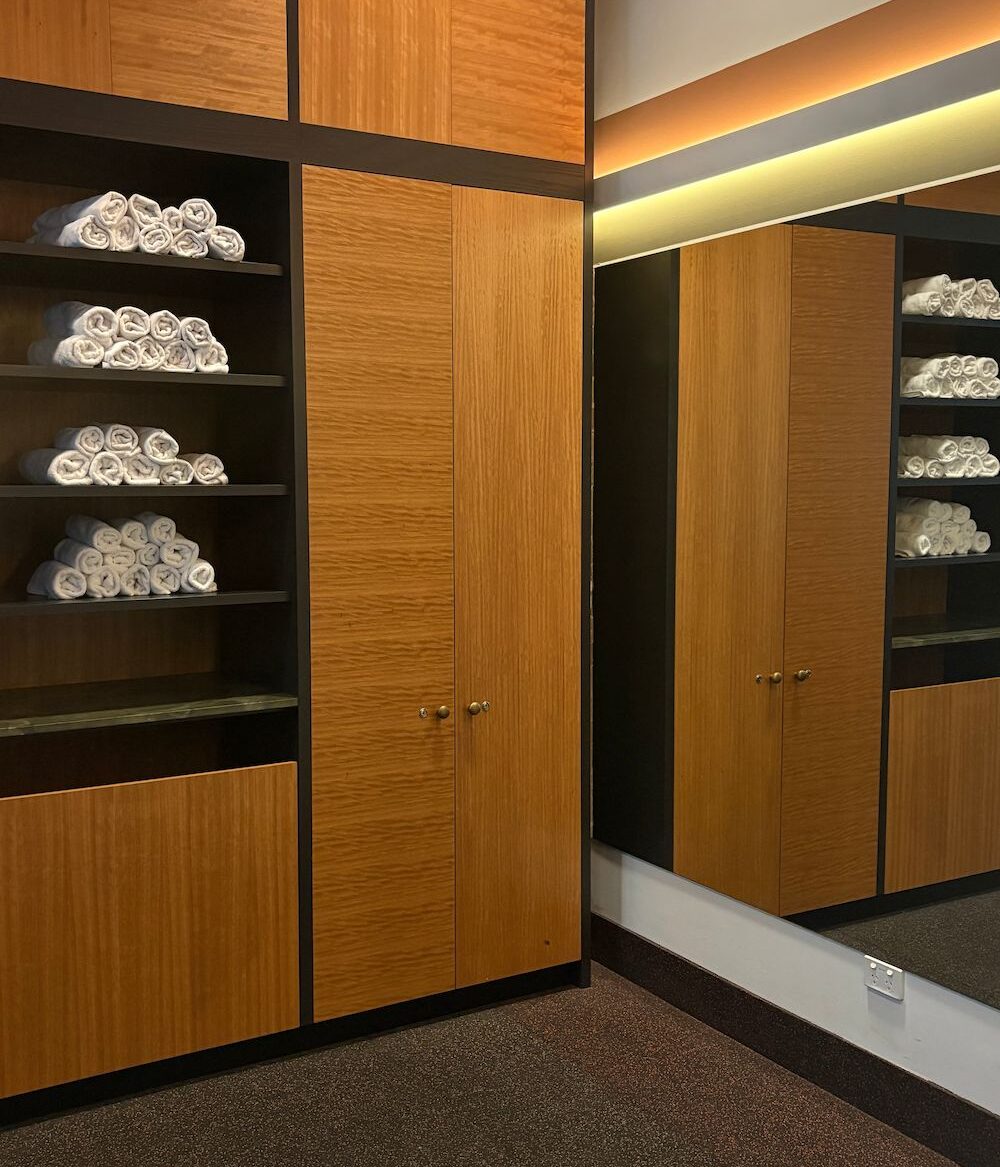 a photo of a gym that shows a workout mirror and clean gym white rolled up towels.