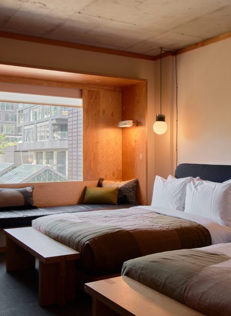 A black leather seating area is next to two bed; plush cushions provide added comfort
