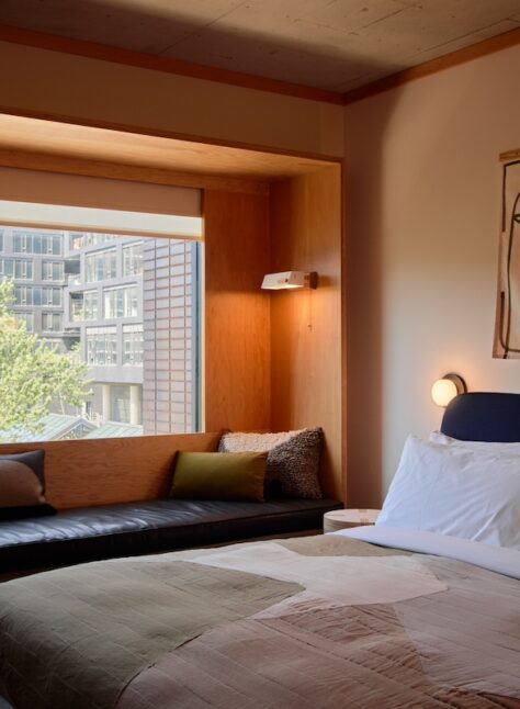 A black leather seating area is next to a bed; plush cushions provide added comfort